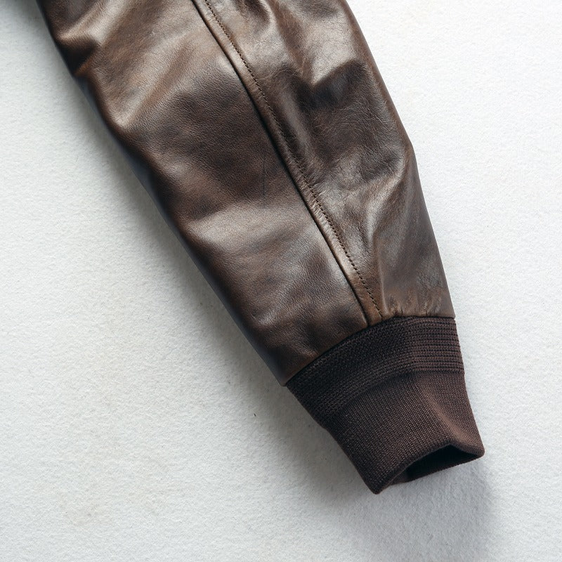 Close-up view of a brown leather jacket sleeve with ribbed cuff, showcasing a rock style design and a vintage vibe.