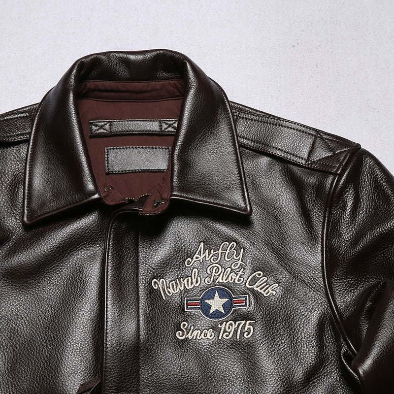 Close-up of a brown leather bomber jacket collar with embroidered Naval Pilot Club design since 1975.