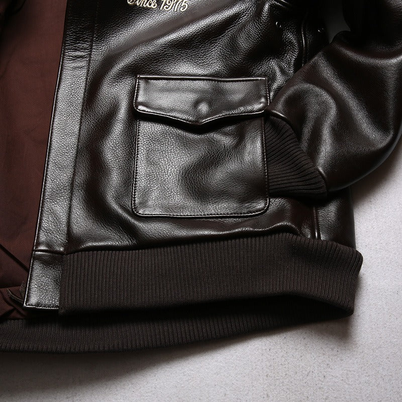 Close-up of a men's brown leather biker jacket featuring a pocket and ribbed cuffs, perfect for a rock style outfit.