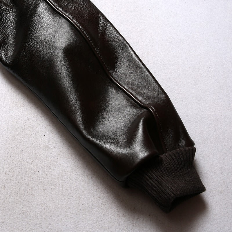 Close-up of the sleeve of a men's leather biker jacket, featuring a sleek design and ribbed cuff.