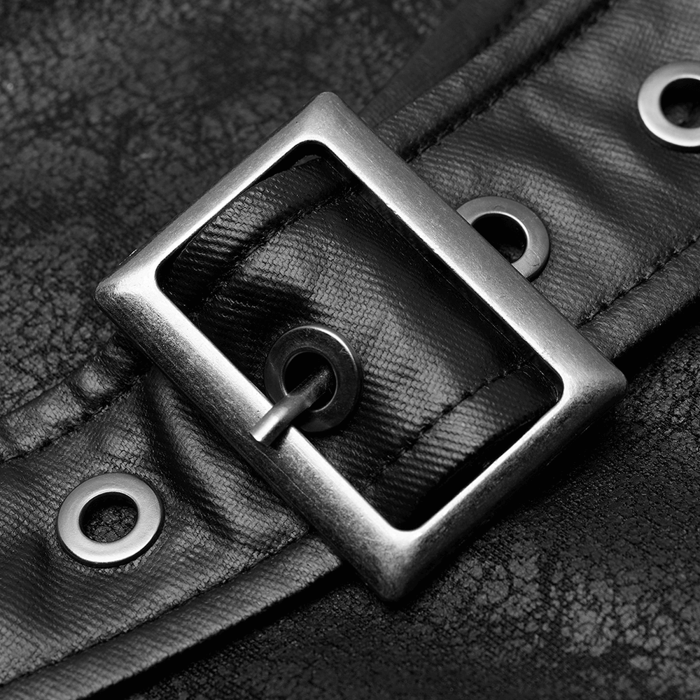 Close-up of a metal buckle on textured black leather, highlighting edgy shoulder harness design.