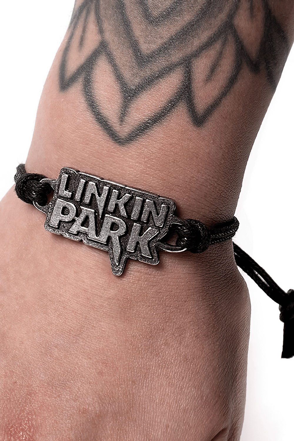 Linkin Park pewter logo bracelet on a wrist with a black cord strap, perfect for rock music fans.