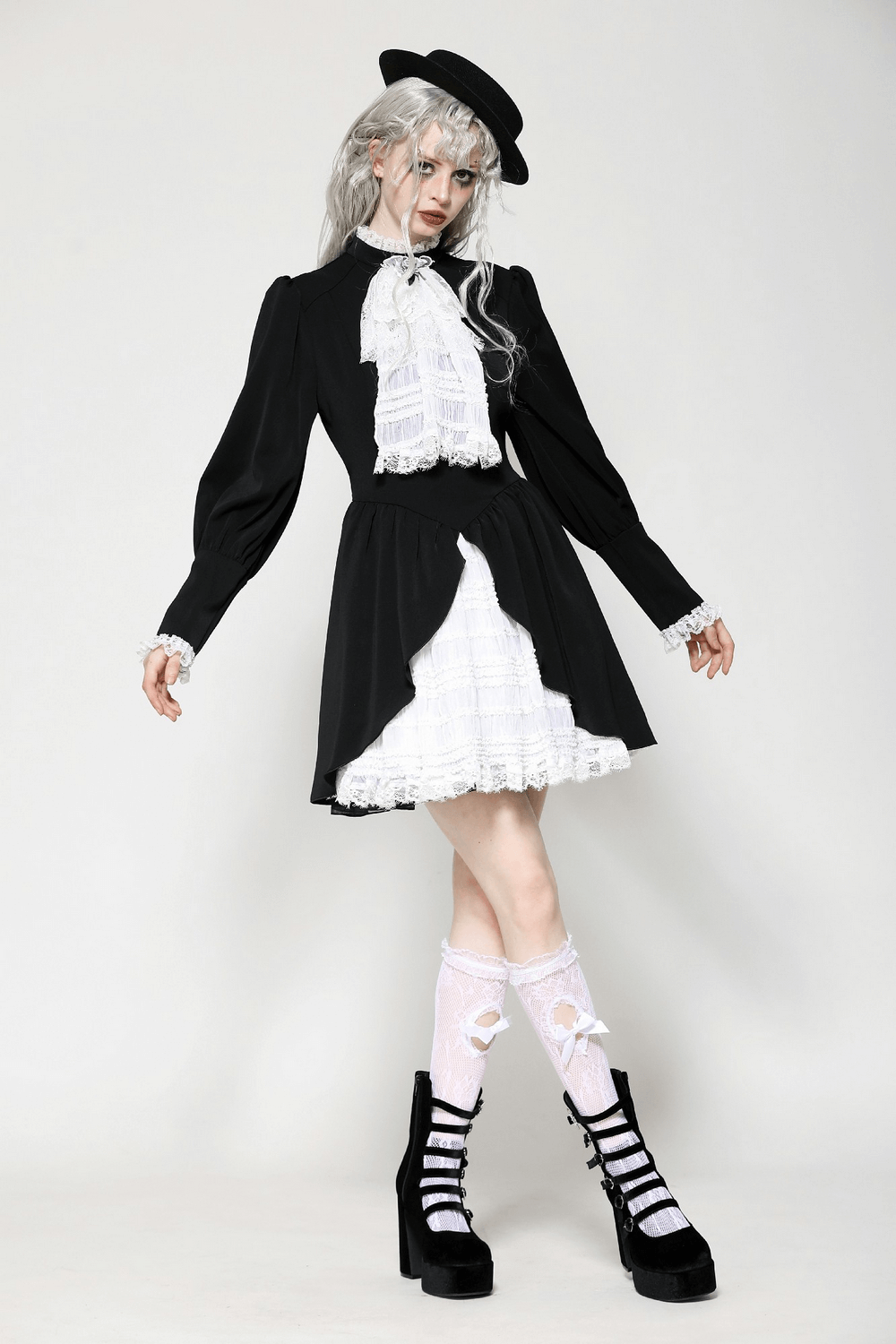 Elegant black and white Gothic Lolita dress with ruffled skirt and lace trim, styled with accessories and striking silhouette.