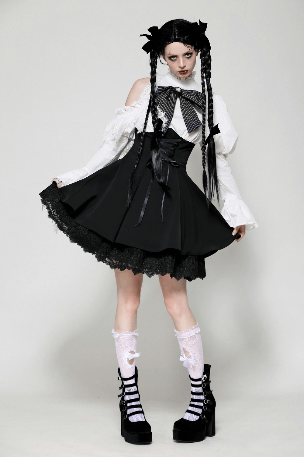 Elegant black and white Lolita dress with lace sleeves, corset waist, and gothic charm, styled with platform shoes.