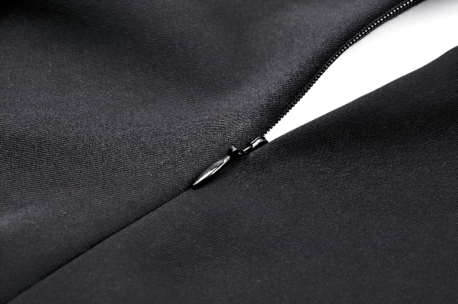 Close-up of a sleek black zipper on a smooth fabric, showcasing high-quality craftsmanship and elegant design.