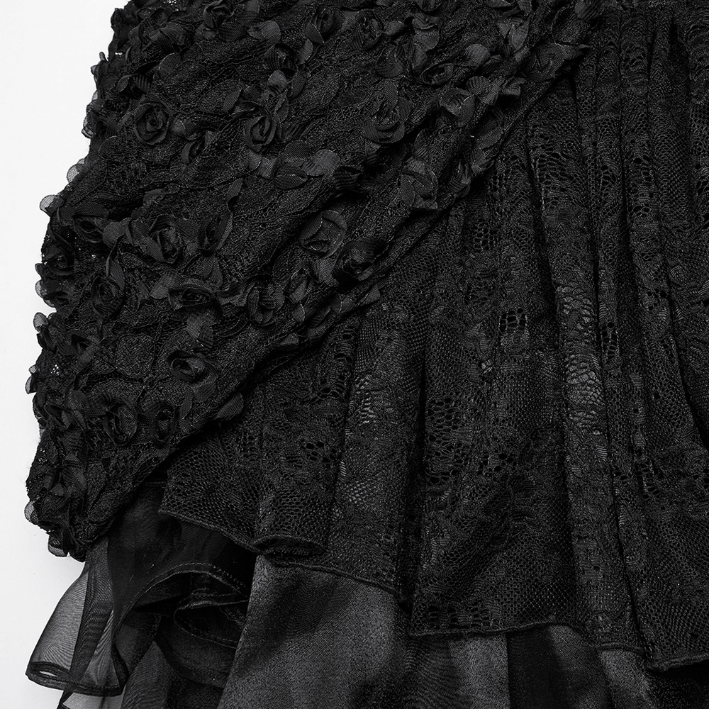 Close-up of black lace fabric with 3D rose embellishments and layered skirt for gothic dress elegance.