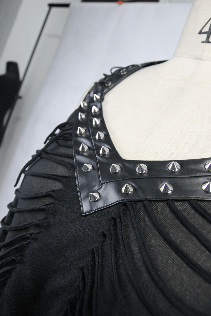 Close-up of women's black punk top with ripped effect and silver spikes on leatherette straps.