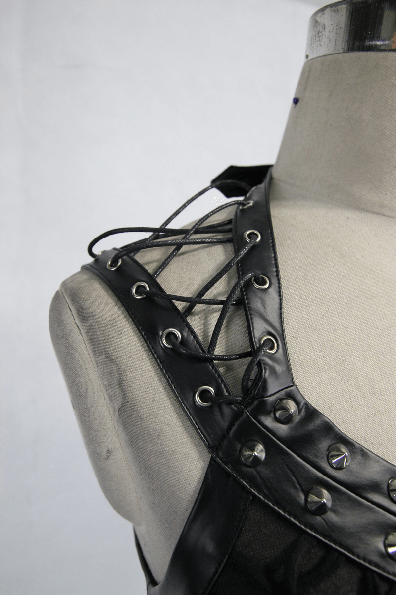 Close-up of a women's black punk top featuring leatherette straps and silver metal spikes.