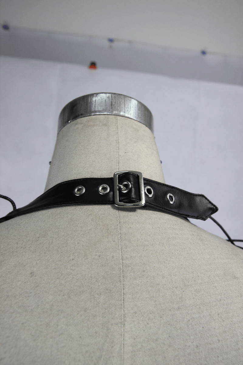 Black leatherette straps with buckle on mannequin showcasing punk fashion details.