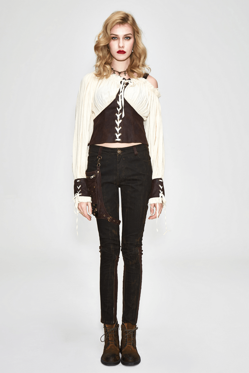 Stylish woman in a beige blouse with front lacing and one shoulder design, paired with black skinny pants and boots.