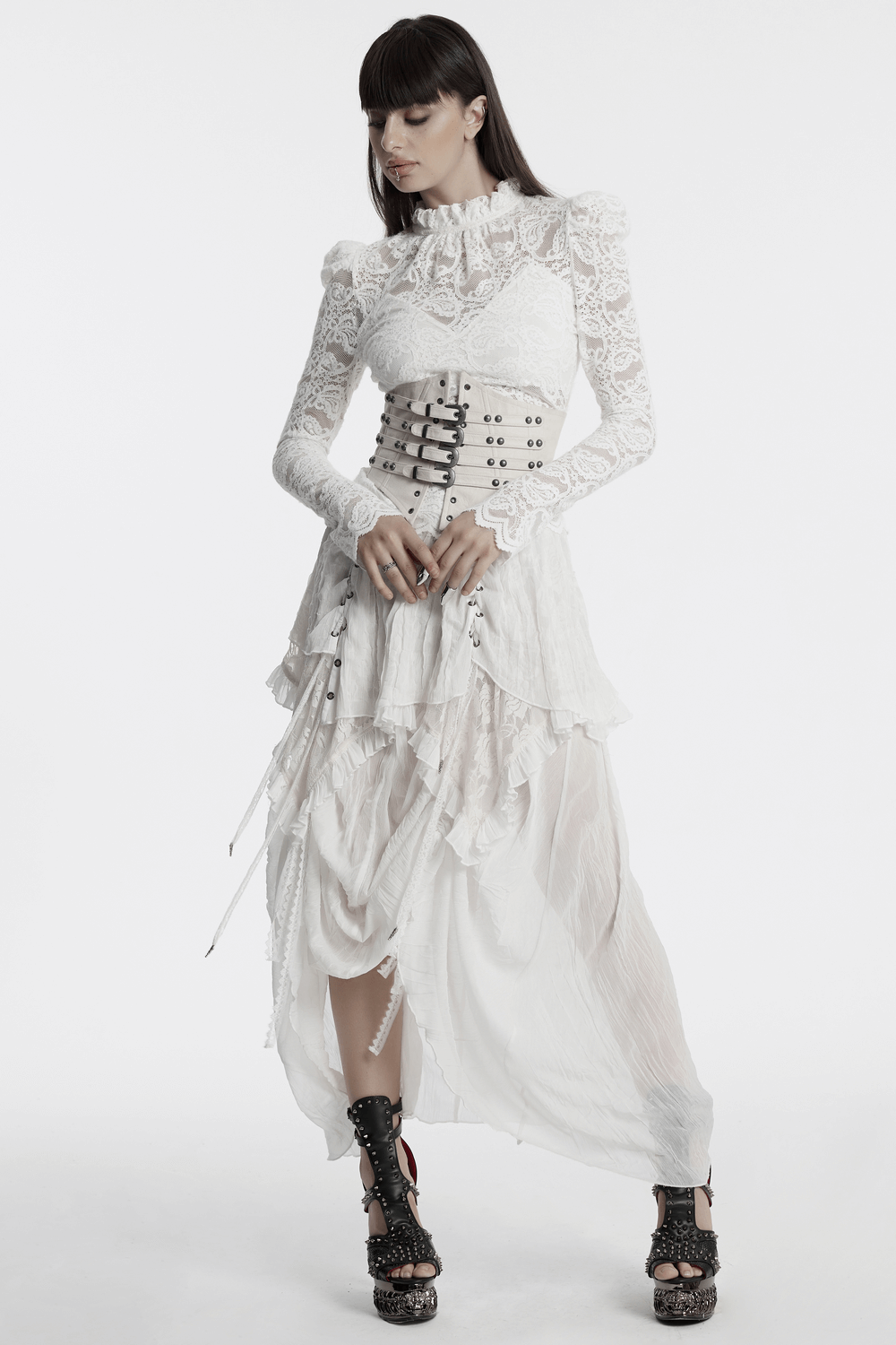 Elegant long-sleeved white lace blouse with ruffled collar, paired with a corset and flowing skirt, perfect for evening events.