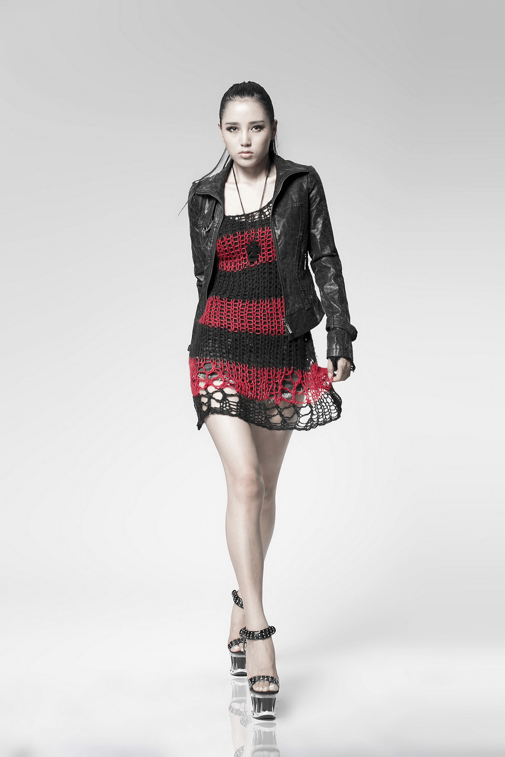 Model showcasing a bold red and black striped crocheted sweater for an edgy fashion statement.