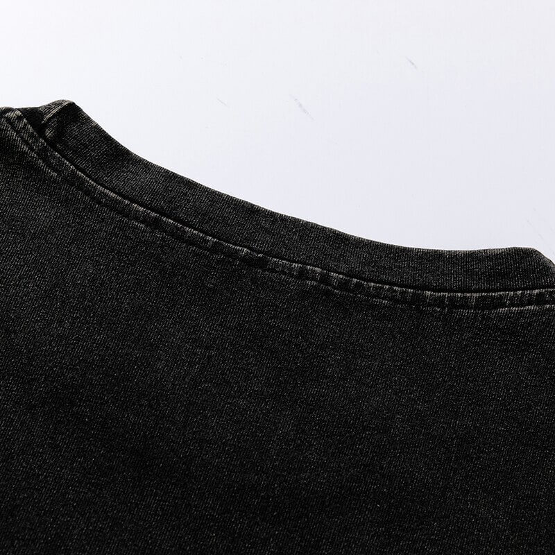 Close-up of the neckline of a loose black cotton T-shirt showcasing its soft texture and gothic style.