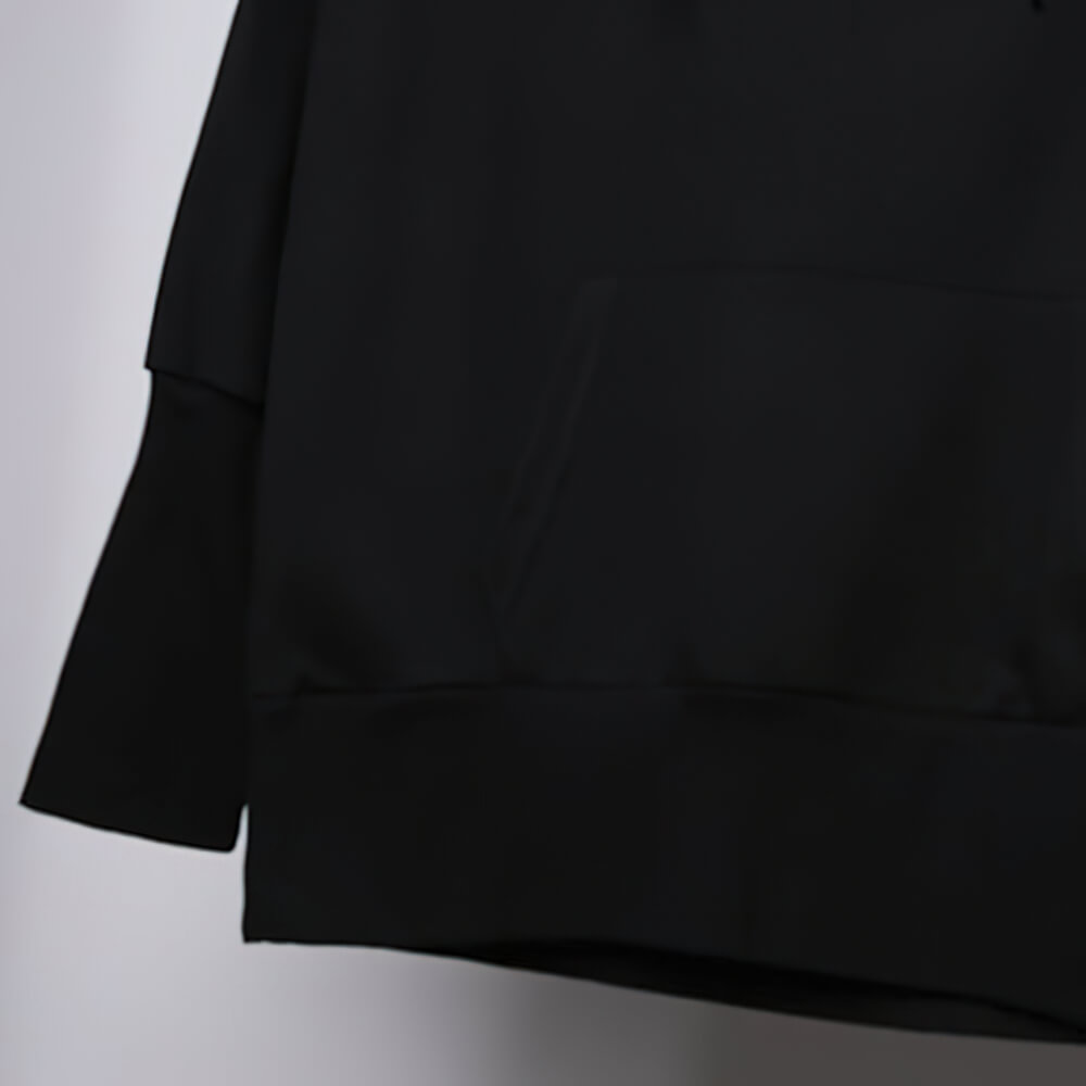 Close-up of a black hooded sweatshirt featuring a kangaroo pocket and relaxed fit for stylish casual wear.