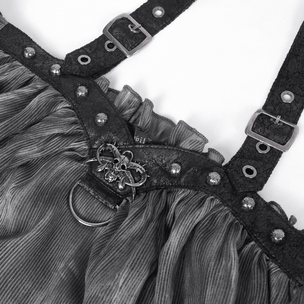 Close-up of dark off-shoulder top featuring buckled straps, metal ring accent, and gothic embellishments.