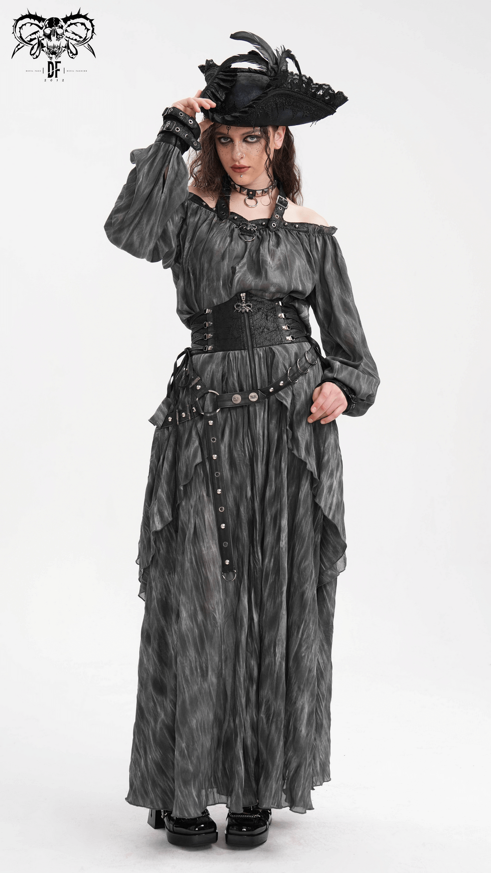 Dark off-shoulder top with gothic charm, buckled straps, and flowing sleeves, styled with a dramatic hat and accessories.