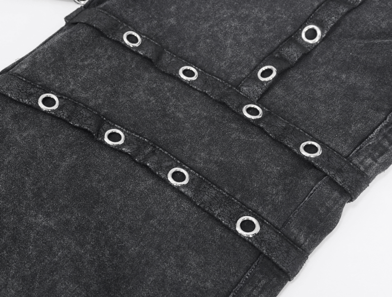 Close-up of loose punk eyelets on gothic pants showcasing unique button closure and dramatic flair.