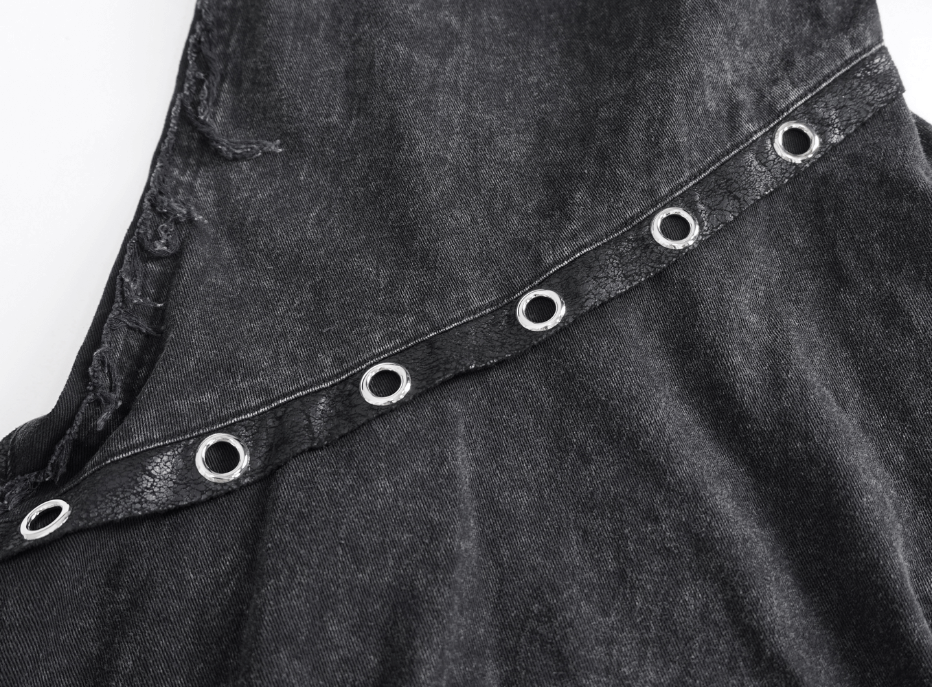 Close-up of loose punk eyelets on gothic flared pants, showcasing unique button closure and lightweight fabric design.
