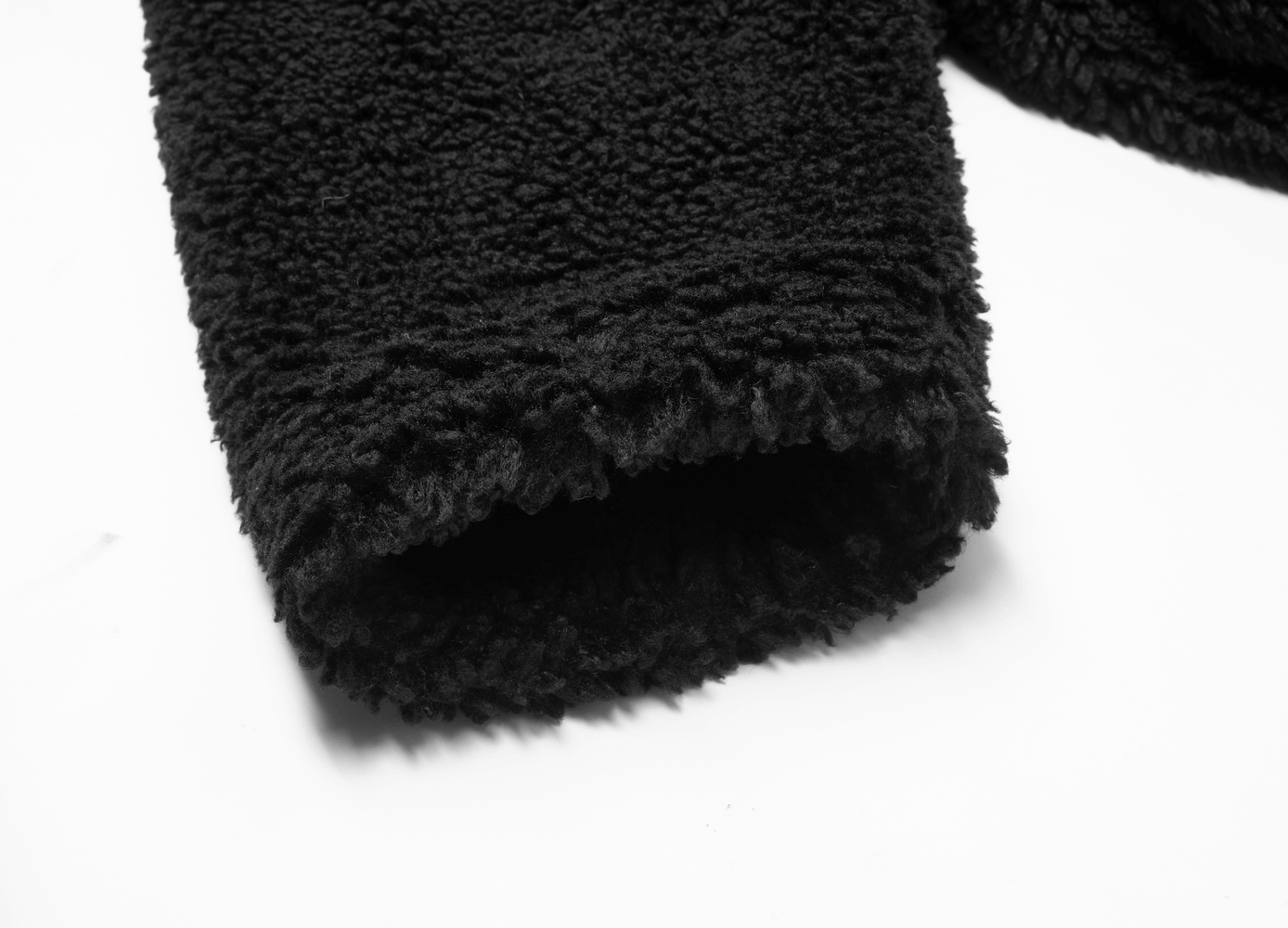 Close-up of the fluffy black cuff of a warm loose jacket for women, showcasing soft texture and cozy design.
