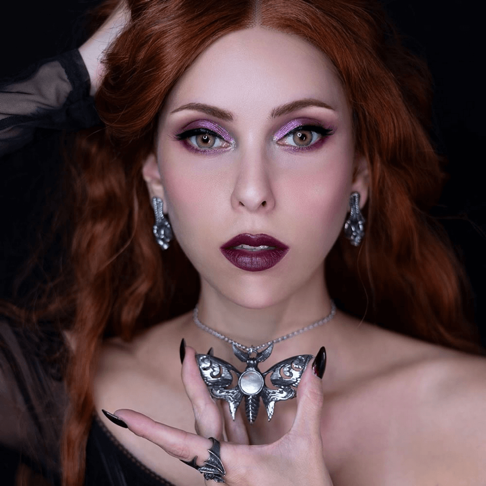 Model showcasing a Lunar Moth necklace with moon phase design and Mother of Pearl inlay.