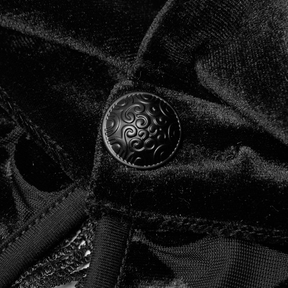 Close-up of ornate black button on luxurious velvet fabric, showcasing gothic elegance and style.