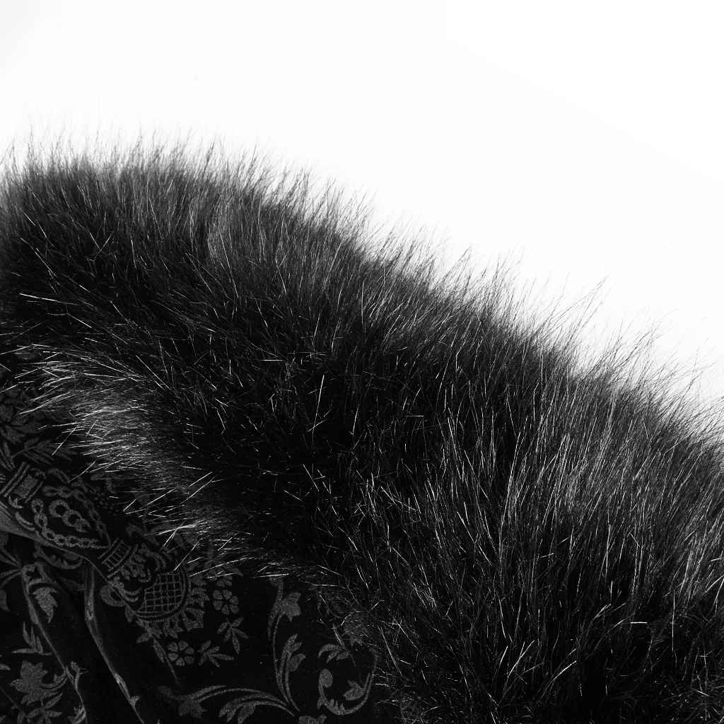 Luxurious black velvet fabric with fuzzy faux fur edging, showcasing gothic style and elegance.