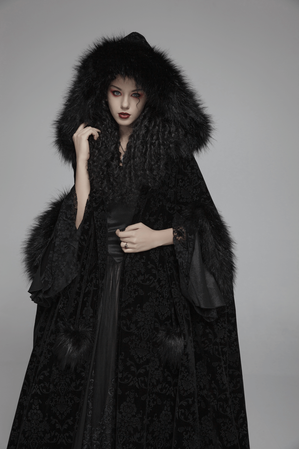Gothic velvet hooded cloak for ladies with dramatic sleeves and luxurious fur trim, exuding nocturnal elegance.