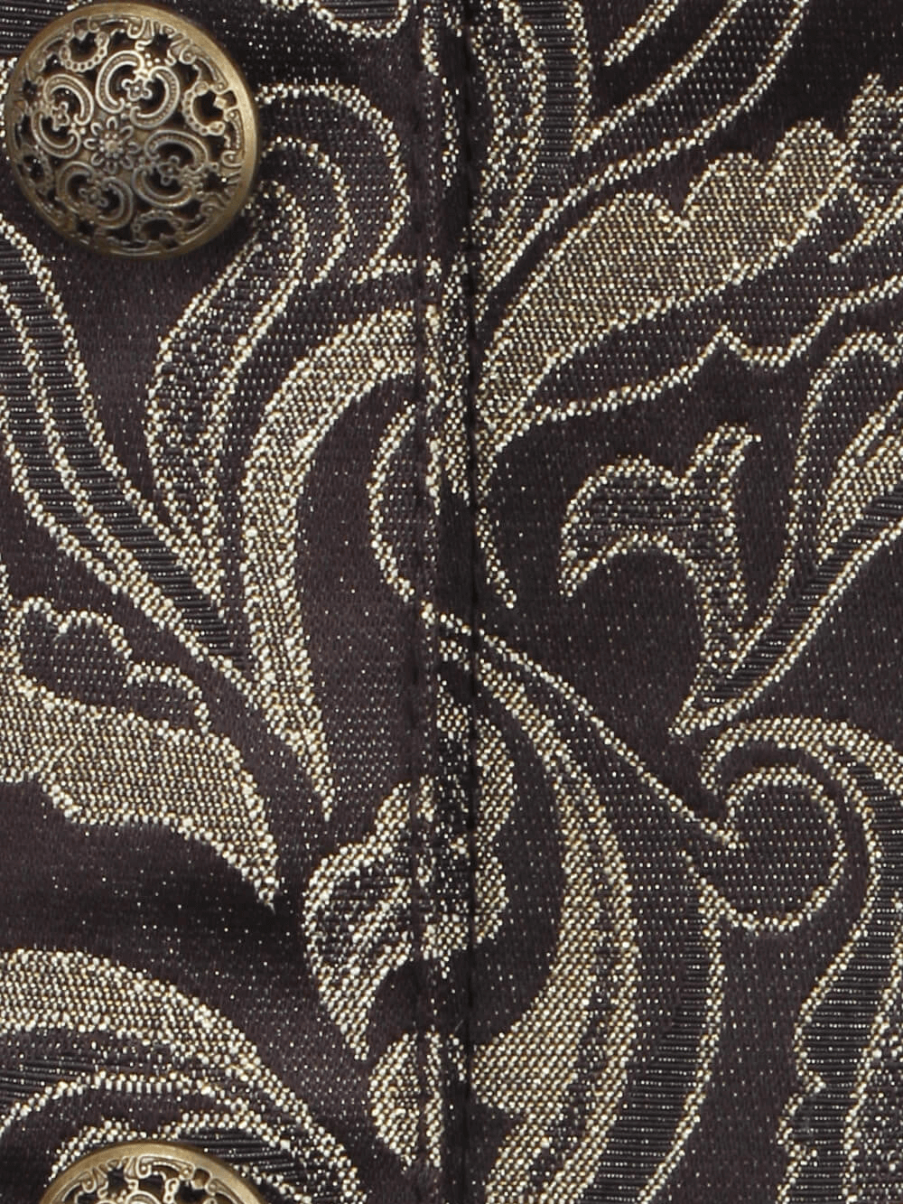 Close-up of luxurious brocade fabric with gold pattern and ornate button, showcasing vintage gothic elegance.