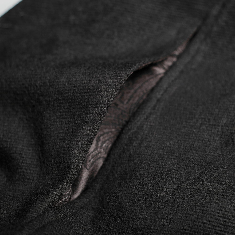 Close-up of luxurious black wool fabric with intricate inner lining, showcasing the gothic style of a premium cloak.