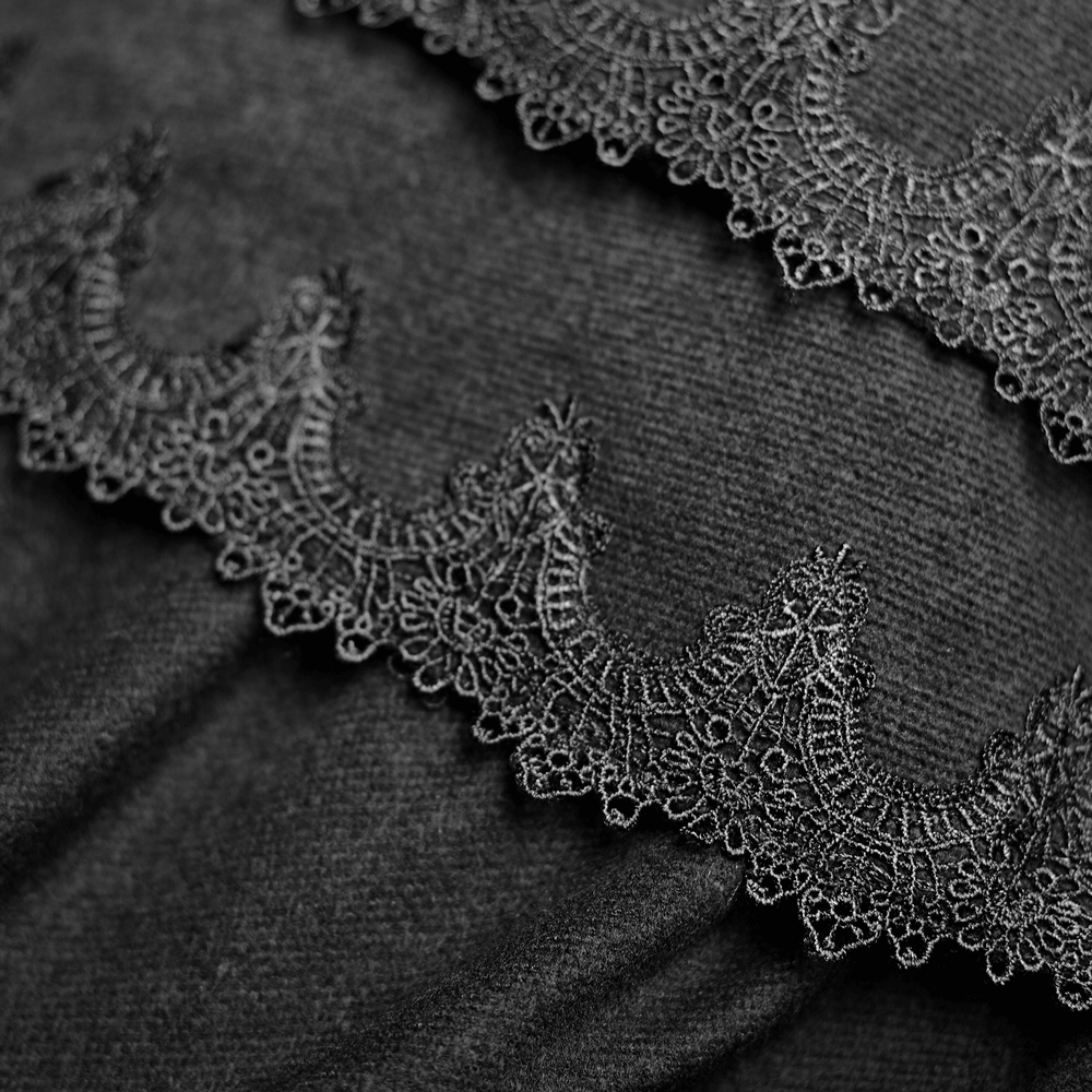 Intricate gothic lace trim on luxurious black fabric, showcasing elegant detailing for opulent cloak design.