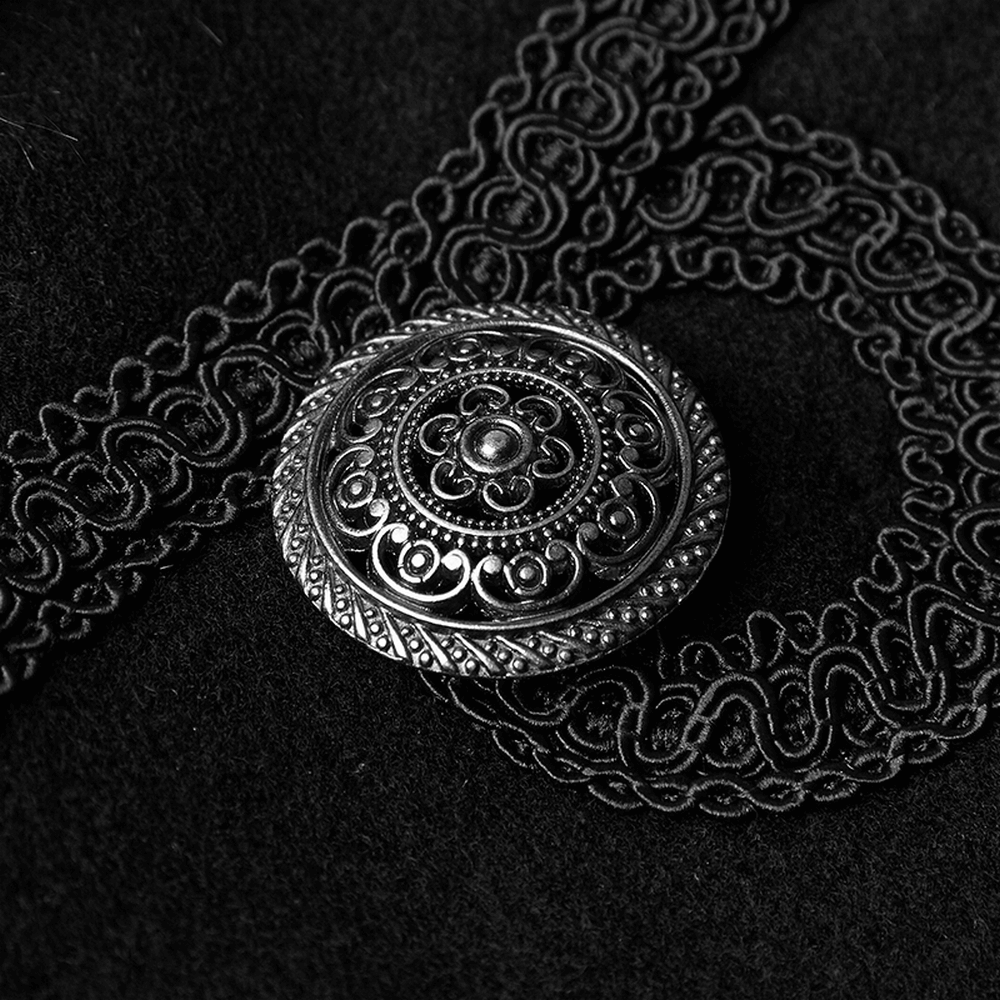 Intricate silver brooch detail on luxurious black fabric, enhancing Gothic winter cloak style.