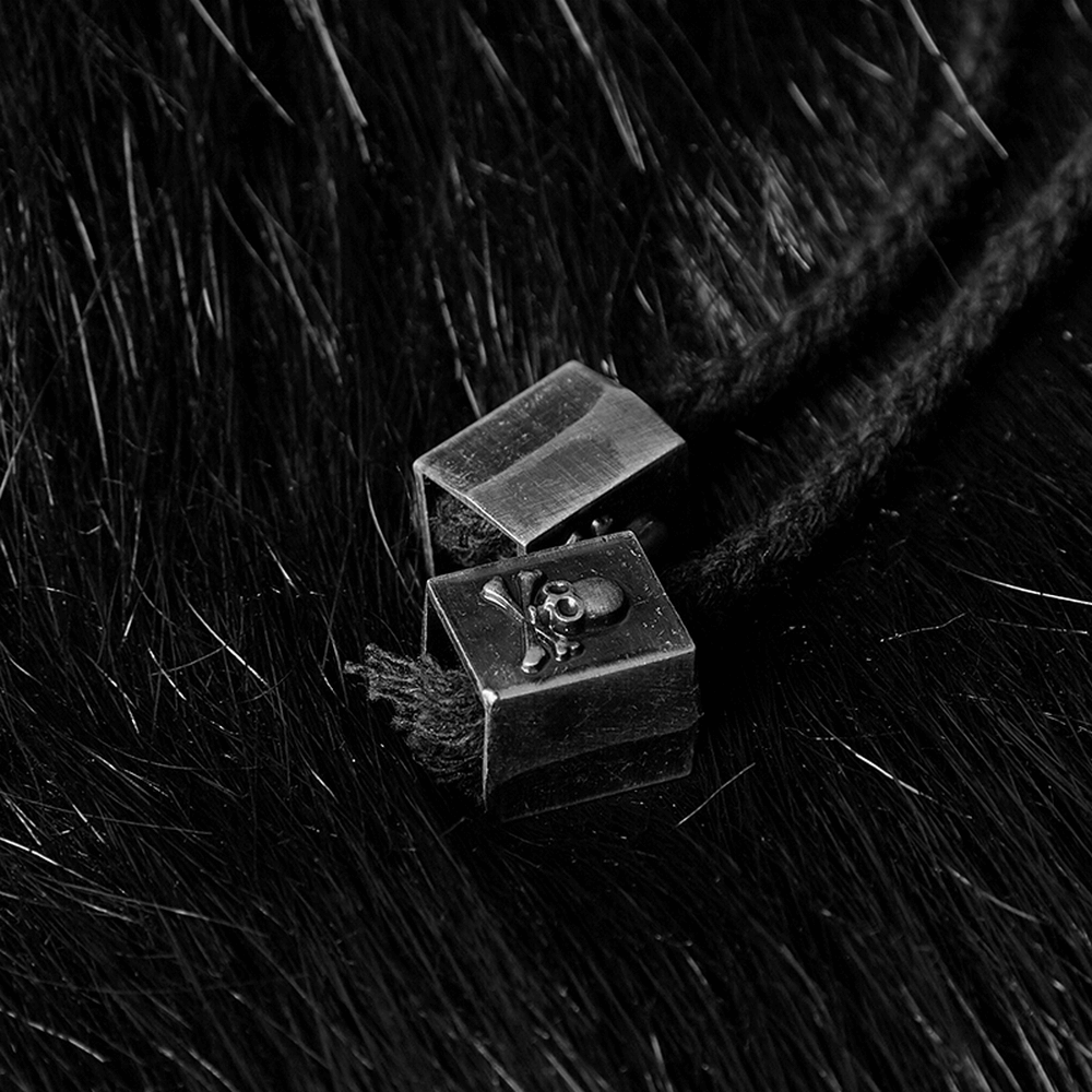 Close-up of silver metal tips on black cord, showcasing gothic aesthetics with a skull design.