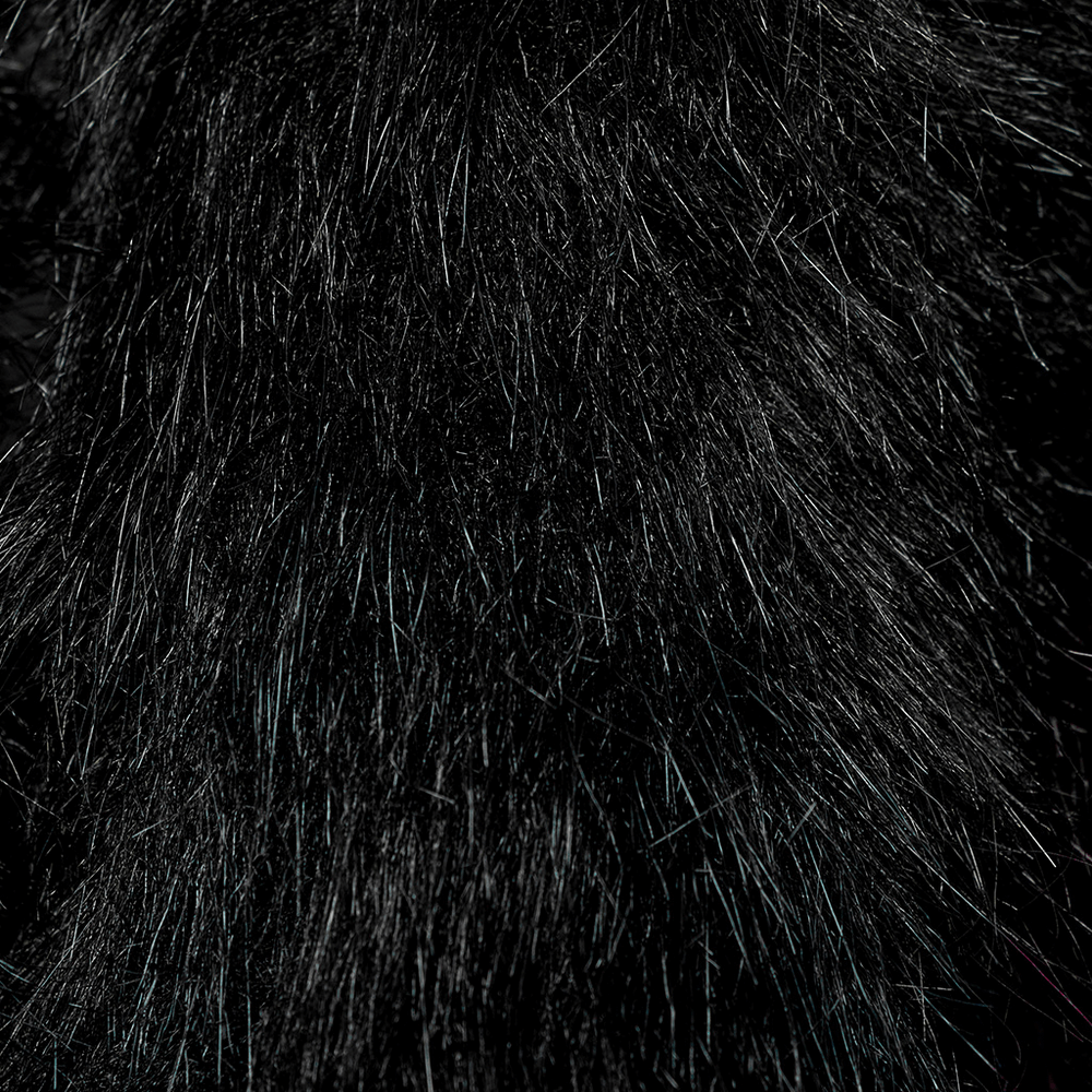 Close-up of luxurious black fur fabric with a soft, textured surface, perfect for gothic or opulent fashion.