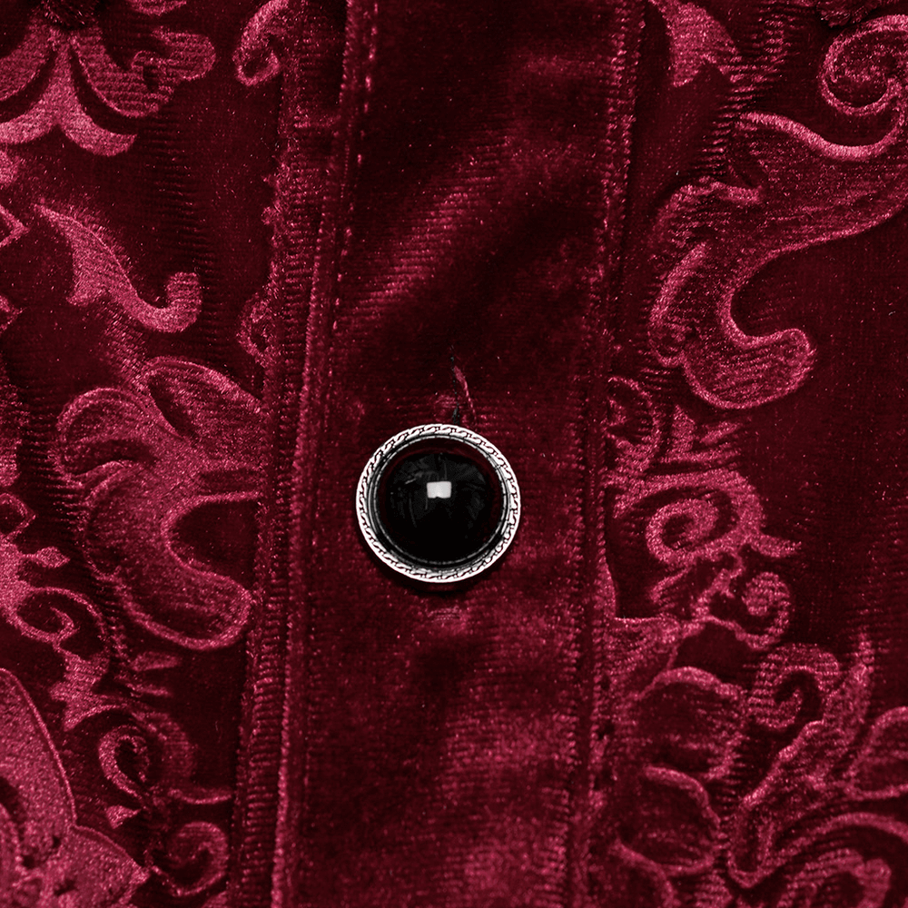 Close-up of elegant red velvet fabric with intricate Gothic patterns and a stylish black button detail.