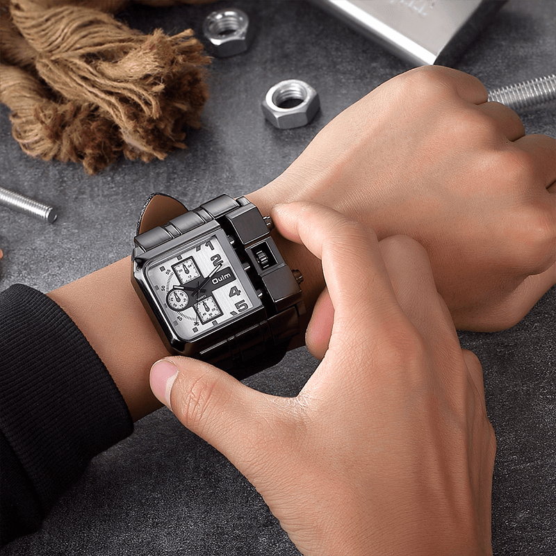 Man adjusting luxury square dial wristwatch with black strap among tools and materials.