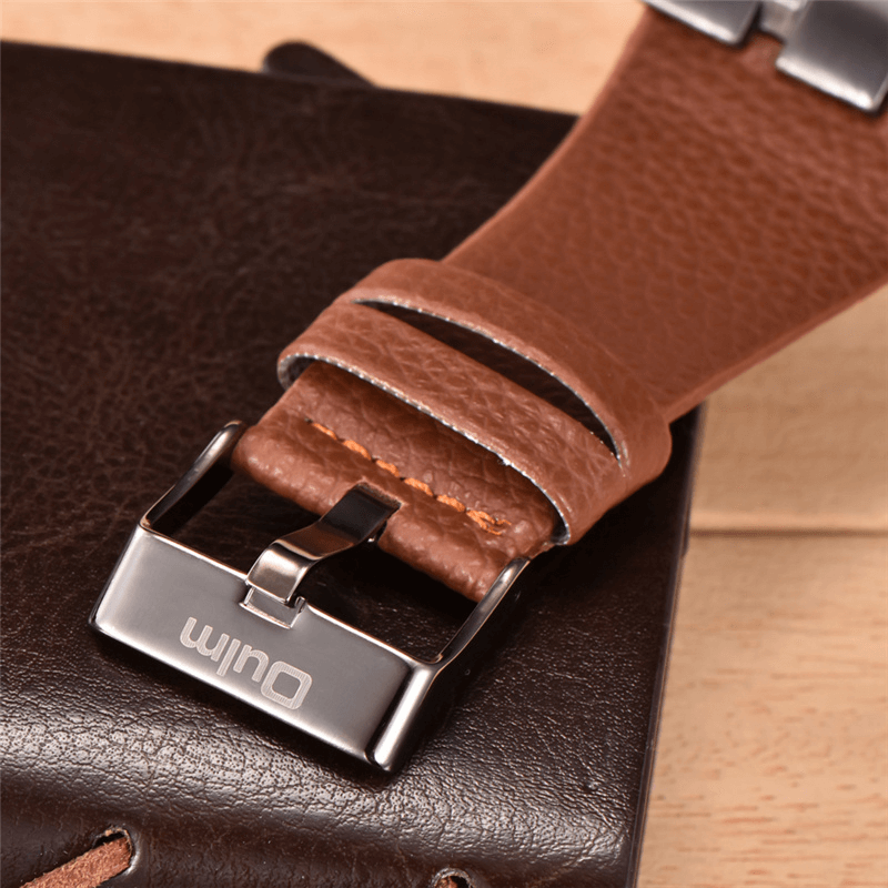 Close-up of a brown leather watch strap with a shiny metal buckle, showcasing luxury craftsmanship.