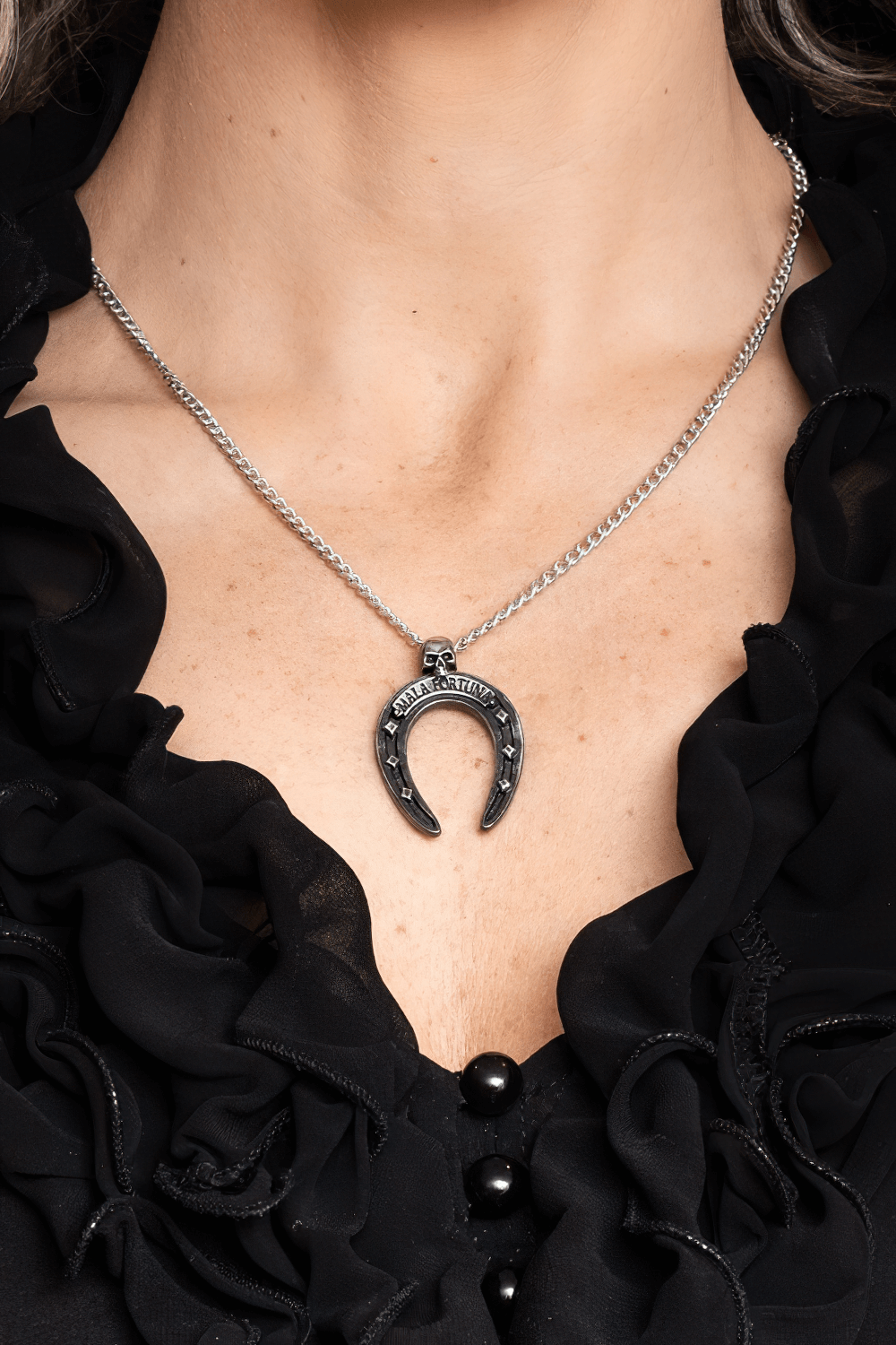 Mala Fortuna Upside-Down Horseshoe Pendant with Skull worn on a model, showcasing its gothic style and unique design.