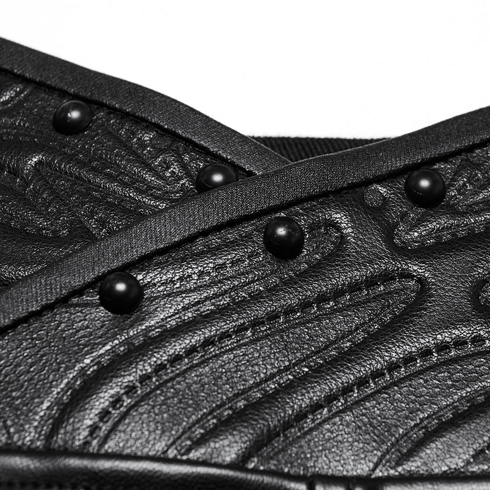 Close-up of black faux leather detailing on pants with unique 3D curved waistband and studded embellishments.