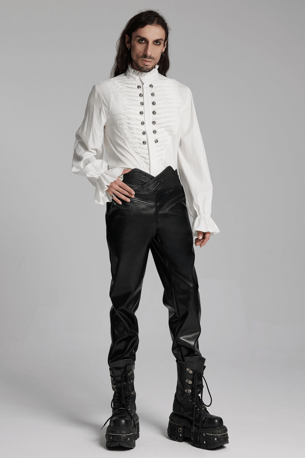 Stylish male model wearing punk black faux leather pants with 3D curved waistband and white buttoned shirt.