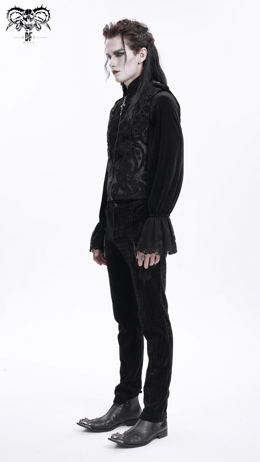 Male model wearing a gothic black brocade waistcoat with intricate embroidery, styled with black trousers and shoes.