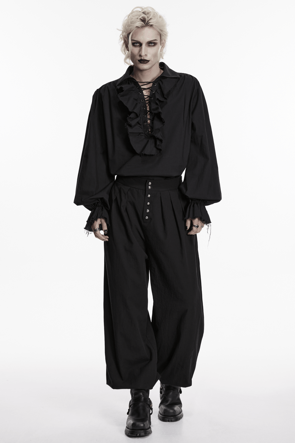 Model wearing Male Black Gothic Pleated Lantern Tapered Pants with ruffled black top in a dramatic pose.