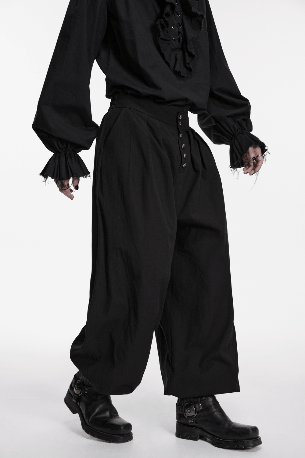 Male Black Gothic Pleated Lantern Tapered Pants worn with a stylish black blouse and boots.