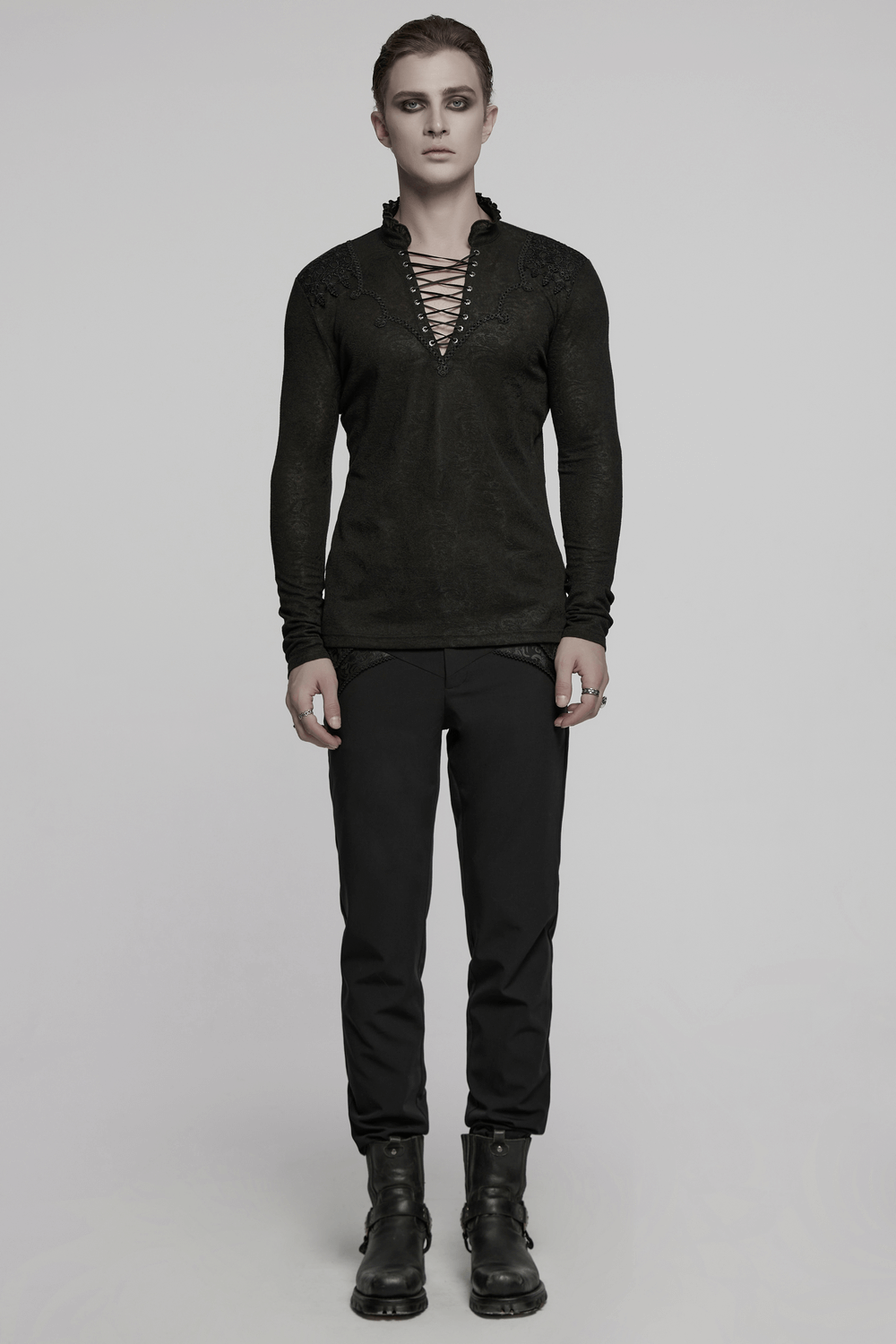 Male model wearing a black lace-up gothic top with ruffled collar and long sleeves, exuding dark romantic style.