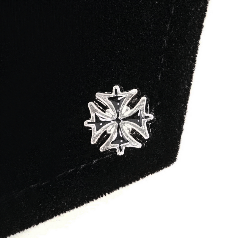 Close-up of a silver medallion with Gothic cross design on a black men's cloak, showcasing elegant detail.