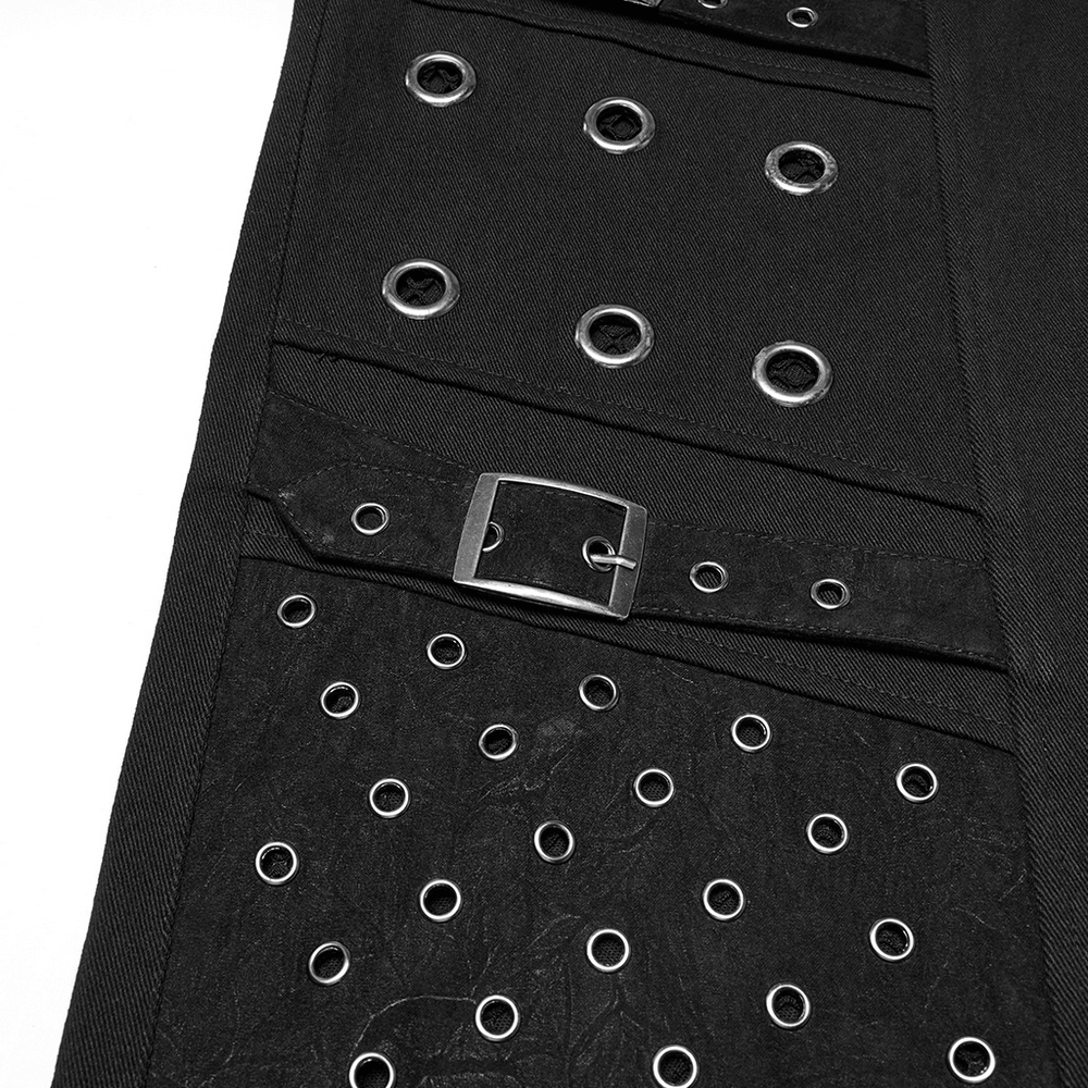 Close-up of black punk pants showcasing multiple metal eyelets and buckle detail, exuding an edgy, gothic vibe.