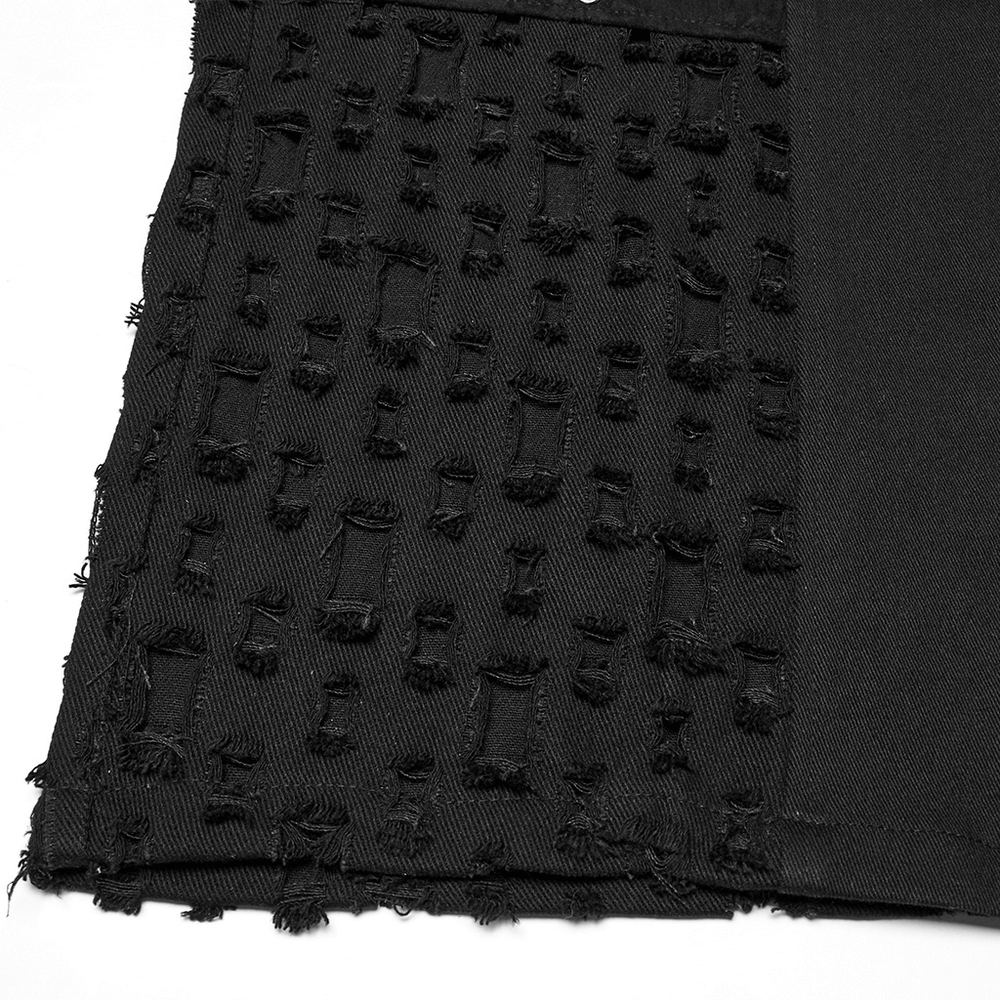 Close-up of black punk pants showing textured faux leather and tattered mesh panels with metal eyelets for a gothic style.