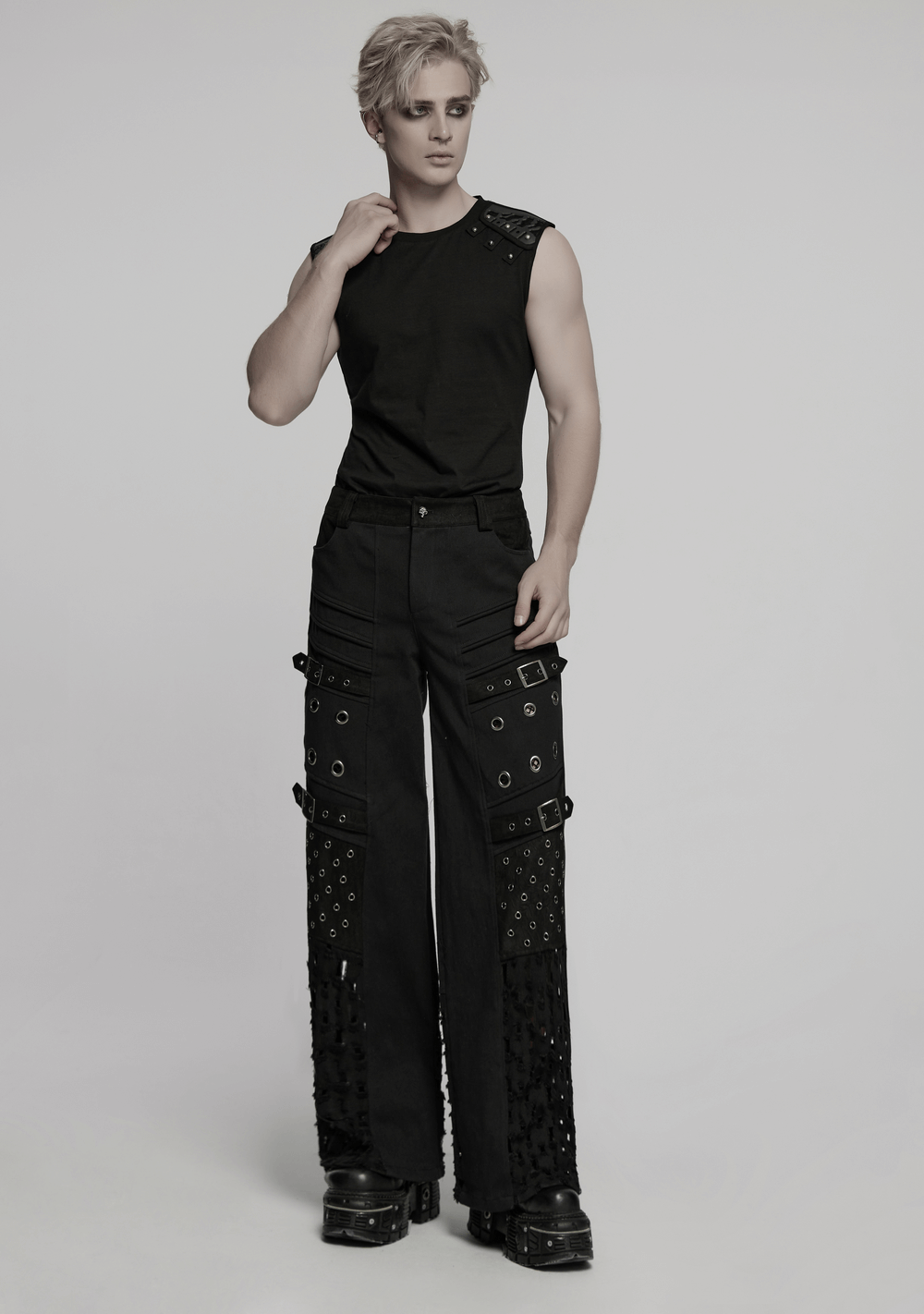 Male model in black punk pants with eyelets and mesh panels, showcasing gothic cyber style and rebellious flair.