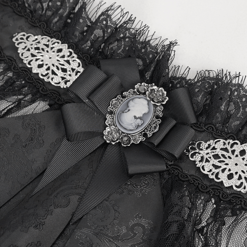 Close-up of a black retro ruffle bow tie with lace details and a vintage cameo brooch, perfect for gothic style outfits.