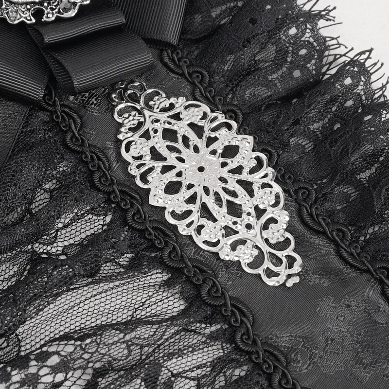 Close-up of black lace fabric with intricate silver detailing and ruffle accents, perfect for gothic fashion.