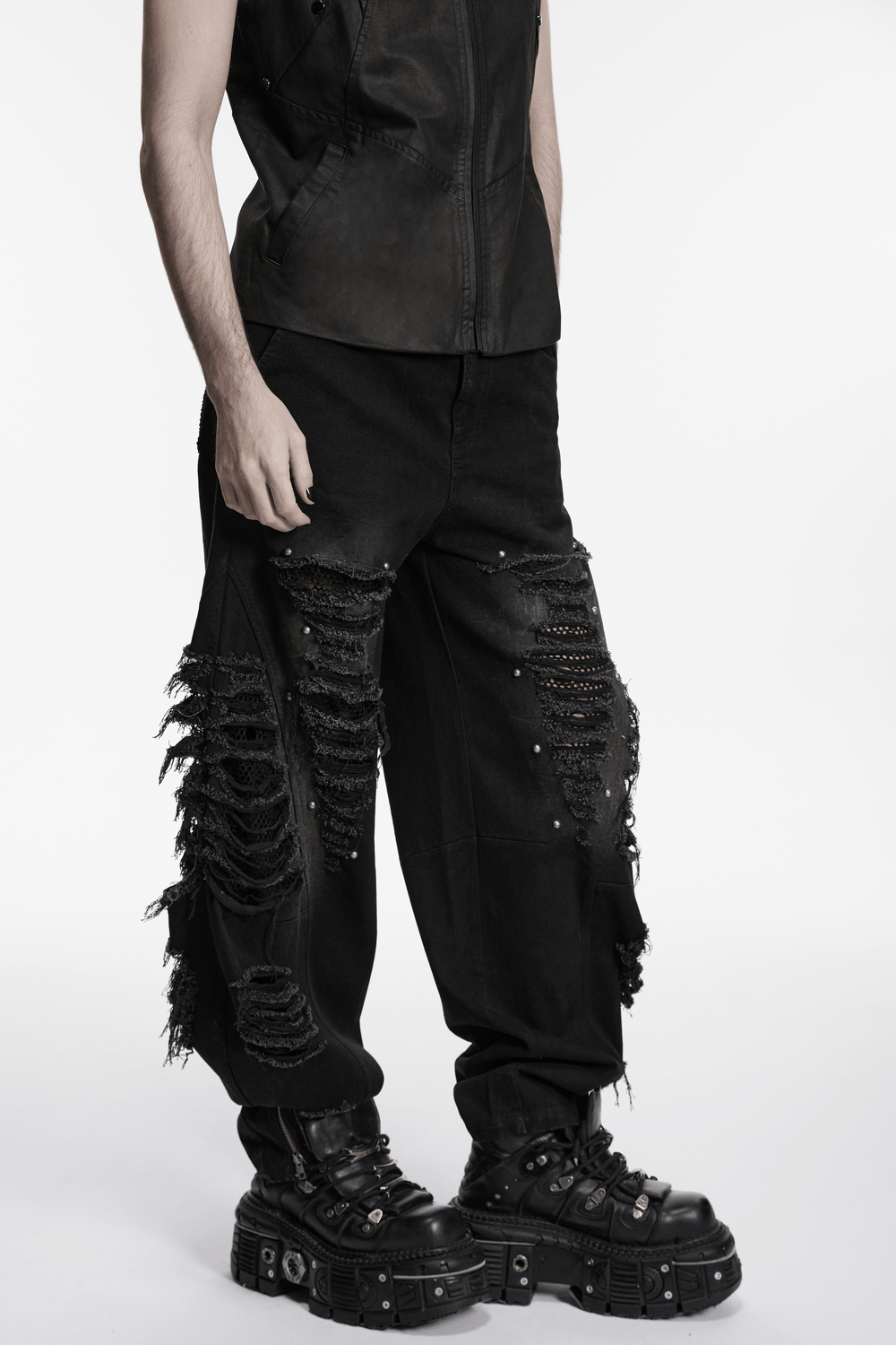 Male Bold Punk Distressed Denim Pants with Studded Rips worn with a black top and chunky boots.